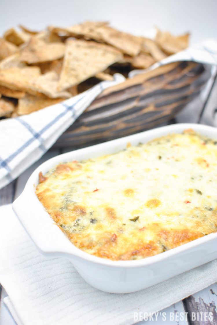 Cheesy Spinach Artichoke Dip with a Kick is the perfect appetizer dip for a game day spread! No mayo, double spinach, four cheeses and just a hint of spice make this ooey gooey yumminess the best spinach artichoke dip I have ever made!! | beckysbestbites.com