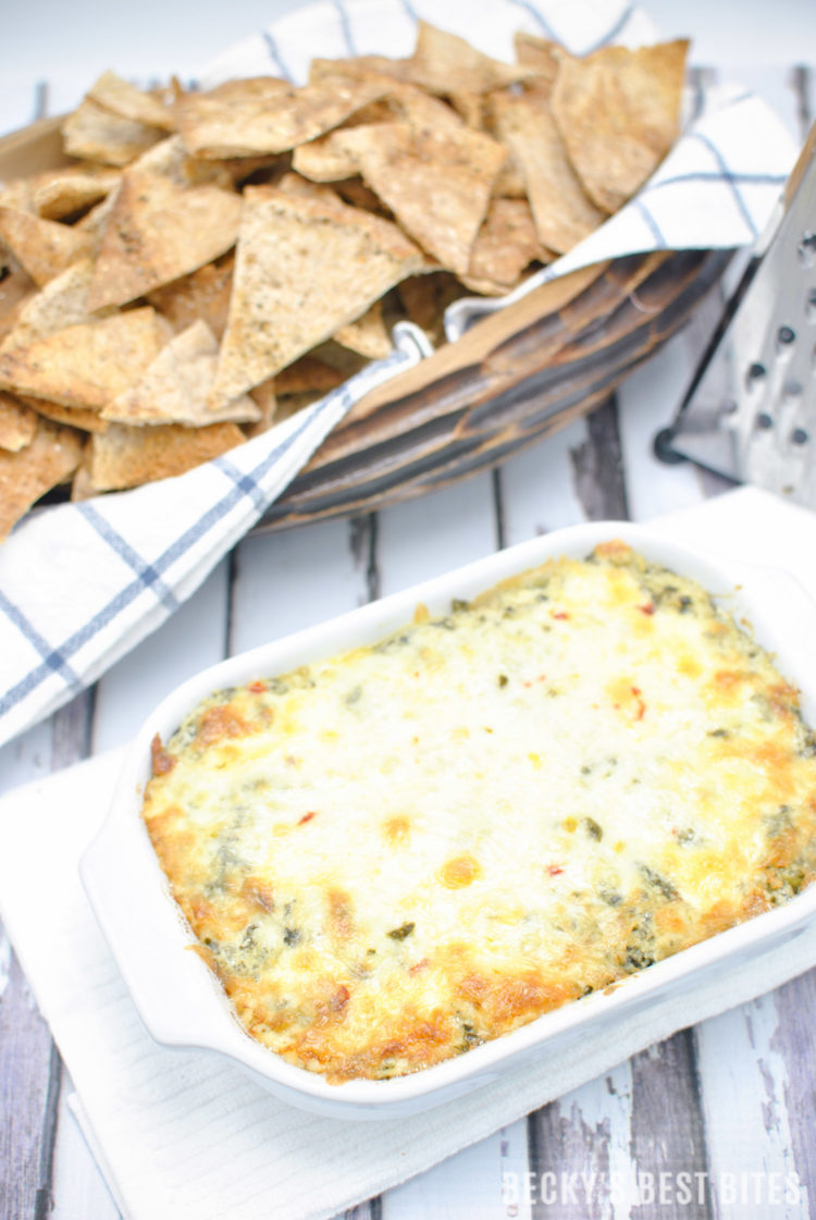 Cheesy Spinach Artichoke Dip with a Kick is the perfect appetizer dip for a game day spread! No mayo, double spinach, four cheeses and just a hint of spice make this ooey gooey yumminess the best spinach artichoke dip I have ever made!! | beckysbestbites.com