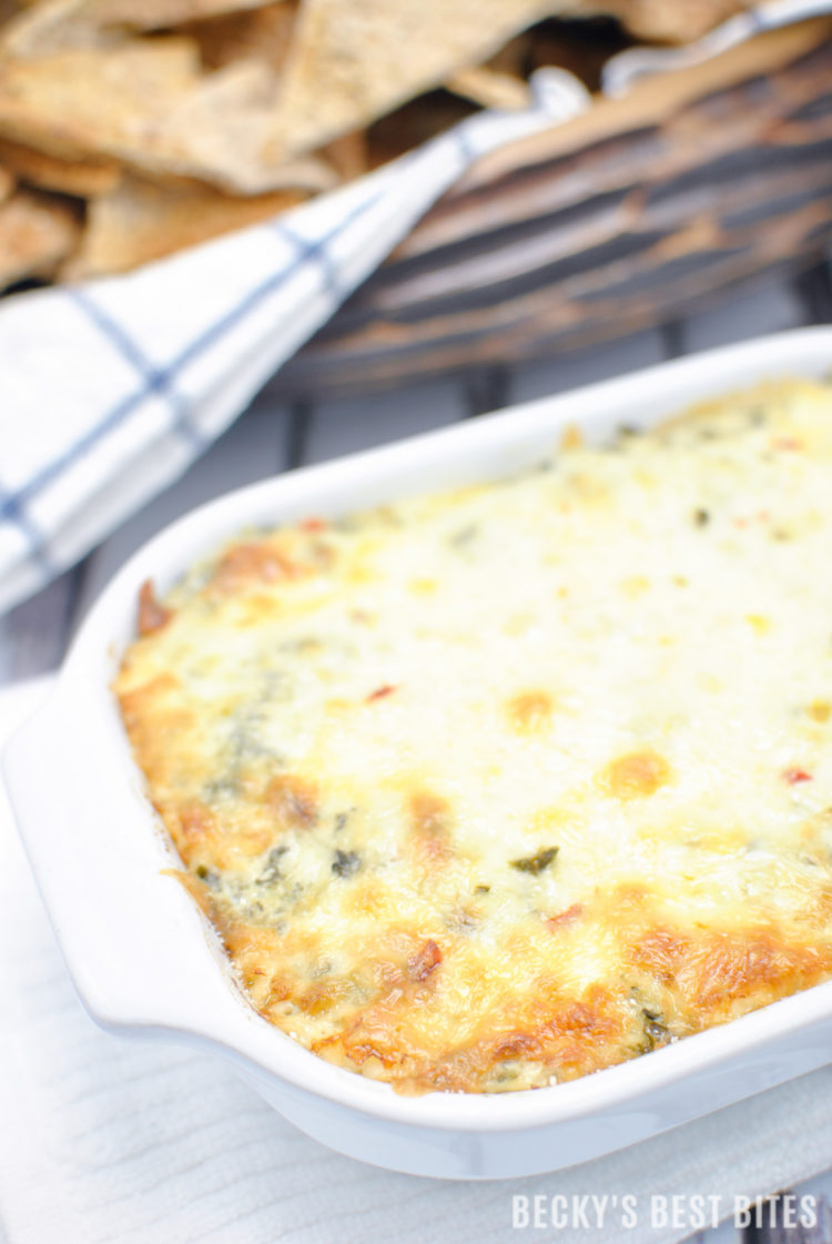 Cheesy Spinach Artichoke Dip with a Kick is the perfect appetizer dip for a game day spread! No mayo, double spinach, four cheeses and just a hint of spice make this ooey gooey yumminess the best spinach artichoke dip I have ever made!! | beckysbestbites.com